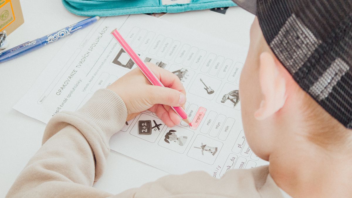 A child working through a homework worksheet with a pencil